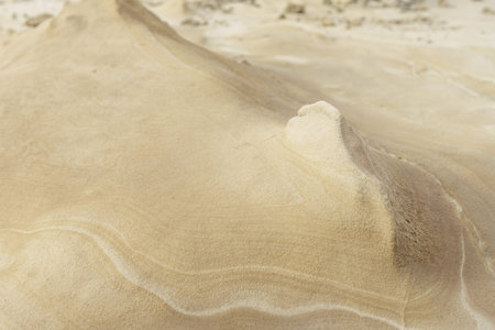 Close-up of a smooth sandstone surface featuring gentle erosion patterns and subtle textures. Ideal for backgrounds, nature themes, and geological studies.の写真素材