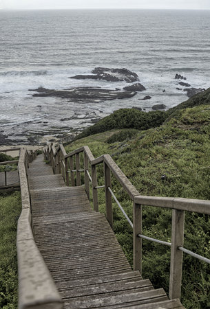 A serene view of Carriagem Beach in Portugal during sunset, with gentle waves lapping against the...