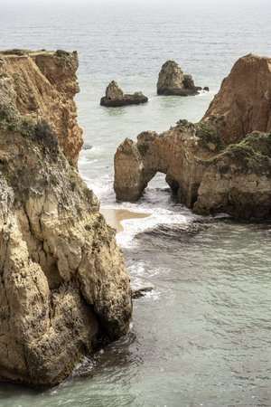 Scenic view of the rocky cliffs and sea stacks at Camilo Beach in Portugal. The rugged coastline...
