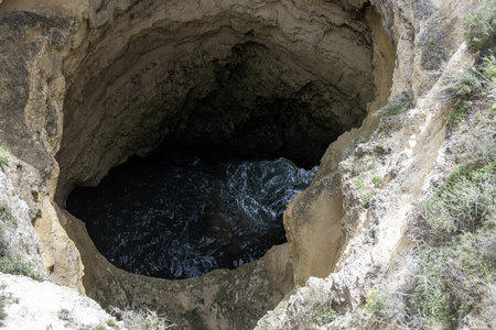 Stunning view of coastal rock formations and sea arches in Portimao, Portugal. The rugged cliffs and scattered sea stacks create a dramatic and picturesque seascape.の写真素材