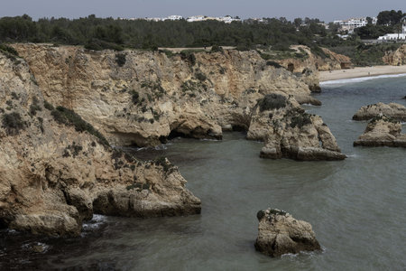 Stunning view of coastal rock formations and sea arches in Portimao, Portugal. The rugged cliffs and...