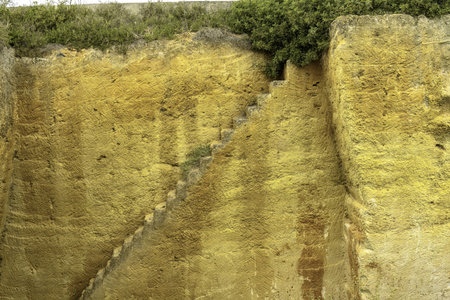A captivating view of the ancient quarry walls at Lithica Pedreres de s'Hostal in Menorca, Spain, showcasing the impressive stone structures and natural greenery.の写真素材