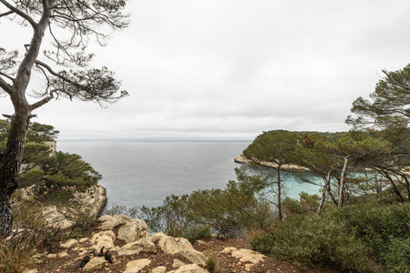 Overlooking the turquoise waters and lush green cliffs of Cala Mitjana in Menorca. A stunning...