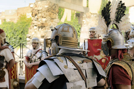 Enthusiastic reenactors dressed as Roman legionaries perform at the Roman Forum in Merida, Spain. The detailed costumes and historical setting bring ancient Roman military life to the present day.の写真素材
