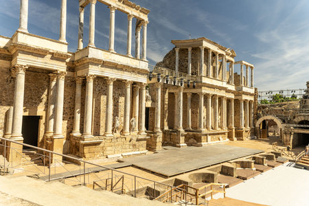 Panoramic view of the ancient Roman theater in Merida, Spain, showing its well-preserved stone architecture and grand stage area under a clear blue sky.の写真素材