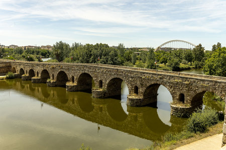 The ancient Roman bridge in Merida, Spain, spans the Guadiana River with its impressive stone arches.の写真素材