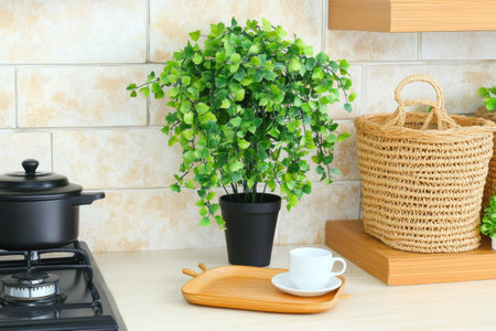 Simple kitchen shelves displaying baskets, mugs, and plates above a marble countertop with a gas stove.の写真素材