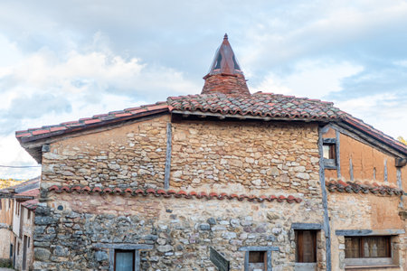 Historic stone house with tiled roof and distinctive turret in the medieval village of Soria, Spain.の写真素材