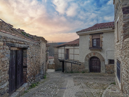 Rustic stone houses along a narrow cobbled street in Yanguas, Soria, showcasing traditional Spanish village architecture.の写真素材