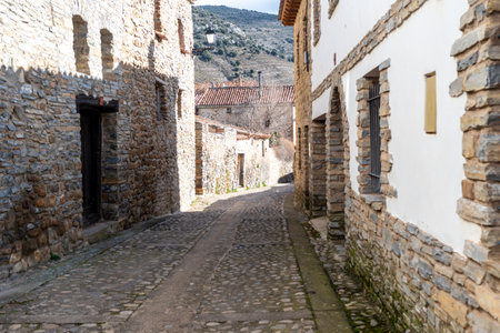 Rustic stone houses along a narrow cobbled street in Yanguas, Soria, showcasing traditional Spanish village architecture.の写真素材