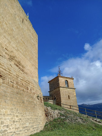Castle keep and bell tower in San Vicente de la Sonsierra, Spain, featuring historic stone architecture, a blue sky, and scenic mountain views.の写真素材