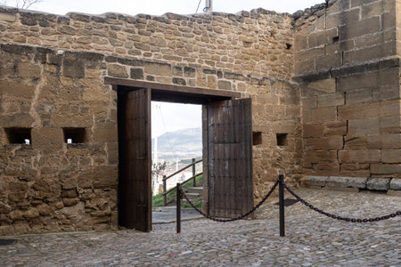 Stone gateway of the medieval fortress in San Vicente de la Sonsierra, Spain, featuring a wooden door, defensive walls, and scenic views.の写真素材