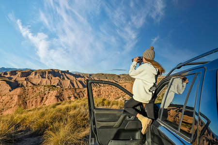 Young girl taking photos of desert landscapeの写真素材