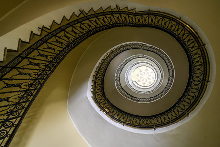 Artistic spiral staircase with intricate railing and central skylight in Ceuta.の写真素材