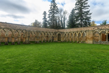 Beautiful stone cloister of the Monastery of San Juan de Duero, with intricate arches surrounding the grassy courtyard in a peaceful setting.の写真素材