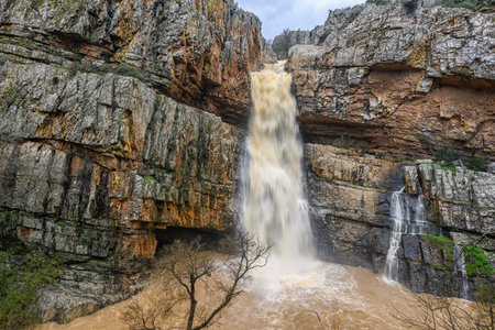 Cascada de la Cimbarra, a stunning waterfall in Spain, cascades over rugged cliffs with powerful water flow, creating a dramatic natural scene.の写真素材