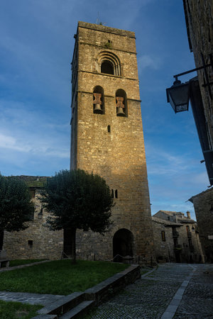 Medieval bell tower of the Church of Santa Maria de Ainsa, with stone architecture and landscaped...