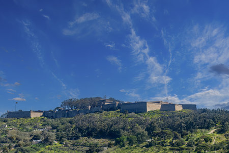 Panoramic view of the Hacho Fortress in Ceuta, surrounded by green hills and blue sky.の写真素材