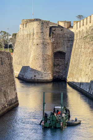 Massive stone bastions of the Murallas Reales in Ceuta reflected in a calm moat at dusk.の写真素材