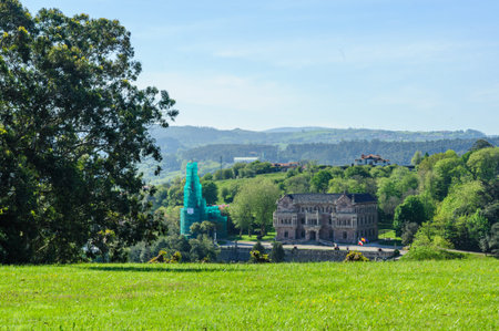 Late afternoon light bathes an ornate historical building surrounded by the lush green canopy of...