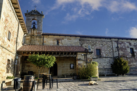 Traditional stone sanctuary with bell tower and rustic architecture in a peaceful courtyard setting.の写真素材