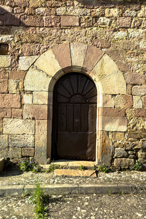lose-up of historic stone arch with wooden door in a rural Spanish church