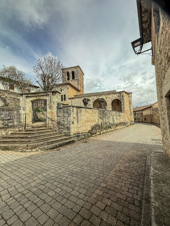 Ancient Romanesque church with arched entrance and stone staircase in a rural Spanish villageの写真素材