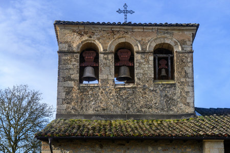 Stone bell gable with three arched openings and bells on historic churchの写真素材