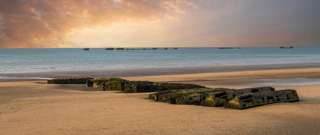 Concrete blocks from the Mulberry Harbor still visible on the beach of Arromanches in Normandyの写真素材