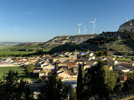 Scenic rural village surrounded by hills and modern wind turbines in Hornillos de Cerrato