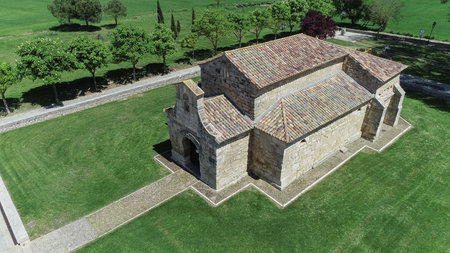 Drone view of ancient Visigothic stone basilica with surrounding green fields and treesの写真素材