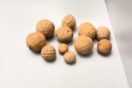 Handcrafted clay balls with geometric engravings from the Vaccean culture on museum displayの写真素材