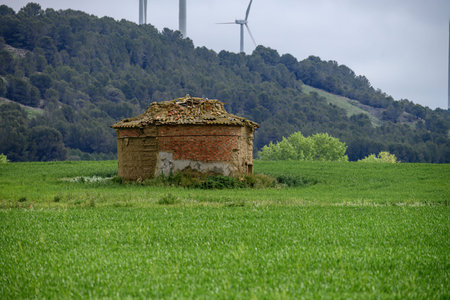 Typical Castilian dovecote with tiled roof standing isolated in rural farmland landscape