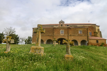 Old stone crosses stand before a rustic brick hermitage in Arenillas de Mazuecos, Palenciaの写真素材