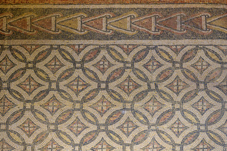 Detailed Roman mosaic with floral and geometric patterns in an archaeological floor settingの写真素材