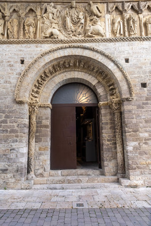 Stone church entrance with carved saints and a Romanesque arch in a historic Spanish town