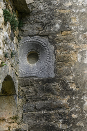 Detailed view of a Romanesque symbol carved into the stone wall of San Martin Church in Barbenuta, Spain.の写真素材