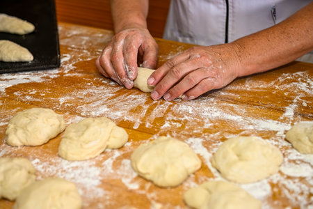 Baker kneading artisan bread in the bakeryの写真素材