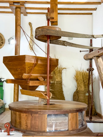 Old wooden grain mill setup with farming tools in a traditional Spanish museumの写真素材