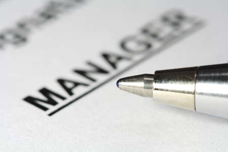 metal pen point on manager word on paperの写真素材