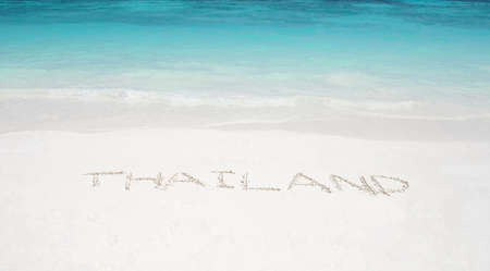 thailand written in a sandy tropical beachの写真素材