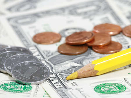 yellow pencil and coin on bill の写真素材