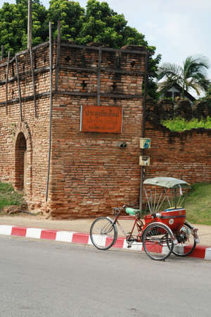 a tricycle and antique Chiang Mai city wall, Thailand のeditorial素材