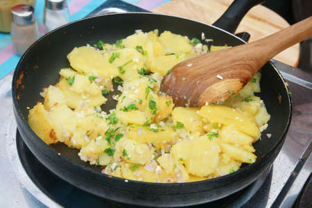 black pan with potato cooking の写真素材
