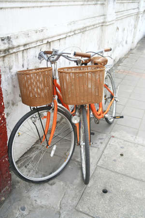 orange bicycle park near wall の写真素材