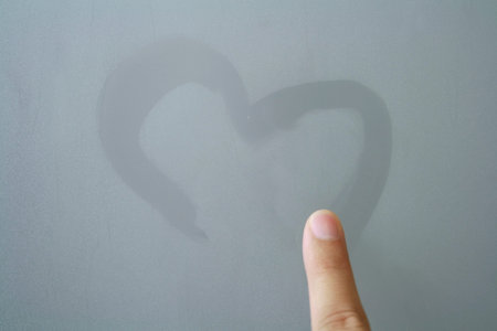 finger written heart on frosted glass の写真素材
