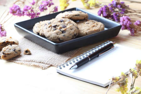 chocolate chip cookie with pen and notebookの写真素材