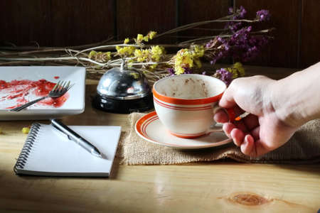 hand with coffee cup and notebookの写真素材