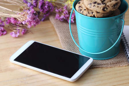 chocolate chip cookie with pen and smartphoneの写真素材