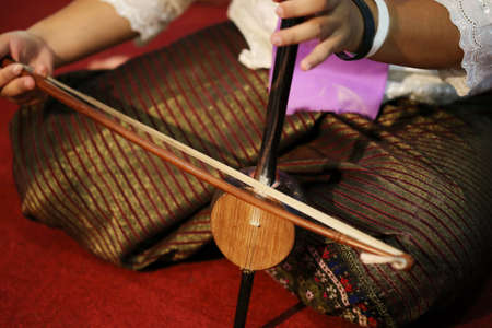 Thai dress in Thai old house playing Thai fiddleの写真素材
